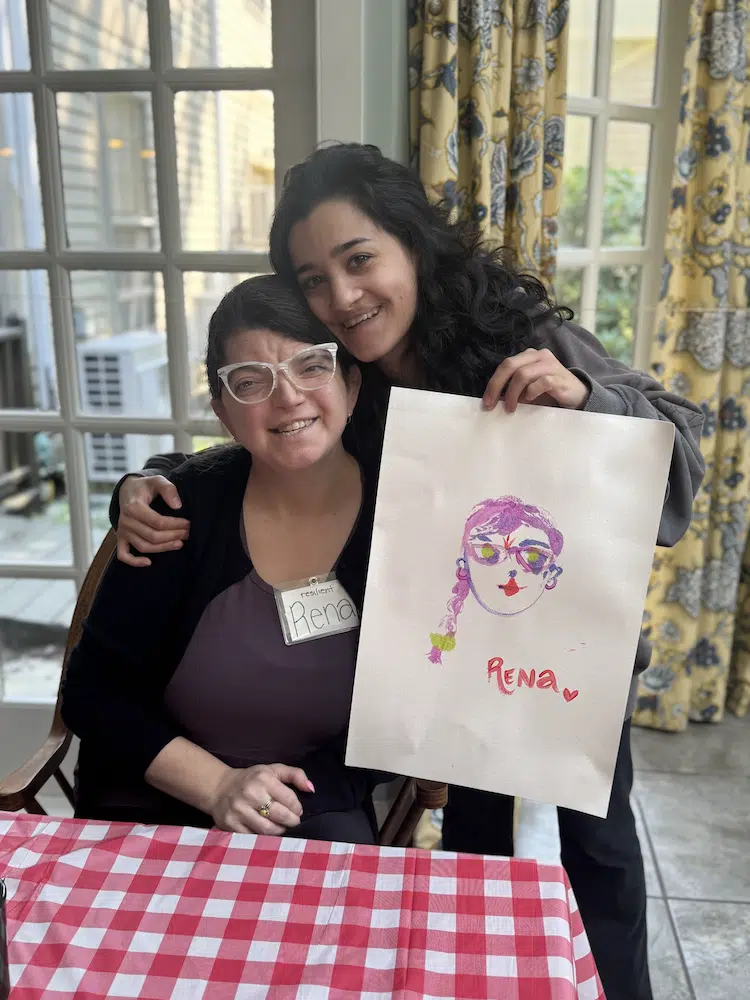 retreat_7 posing smiling with a painting of participant's face